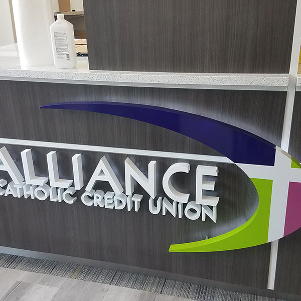 Alliance Catholic Credit Union logo on the front of a gray service counter.