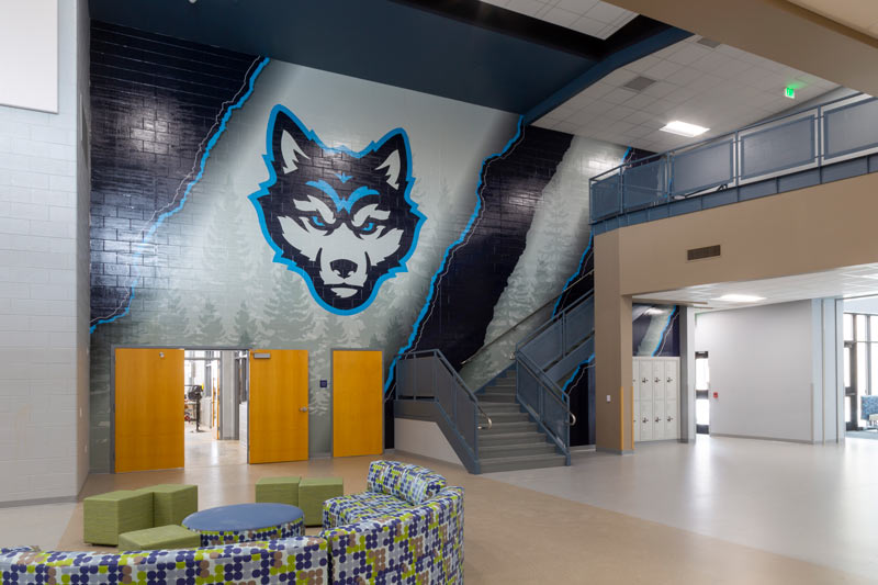 A wolf mascot is featured against the wall of an indoor waiting area.